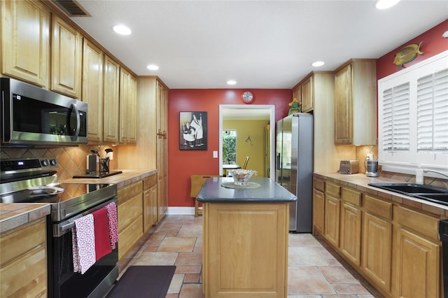 kitchen with stainless steel appliances, a sink, a kitchen island, backsplash, and plenty of natural light