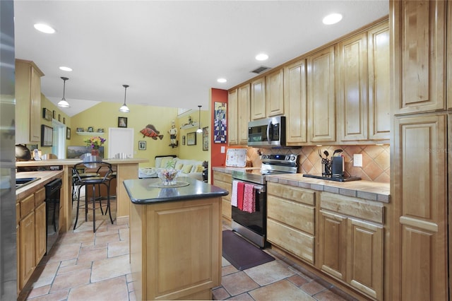 kitchen with a kitchen island, vaulted ceiling, decorative light fixtures, backsplash, and appliances with stainless steel finishes