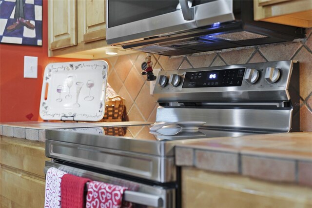 interior space with electric stove and tasteful backsplash