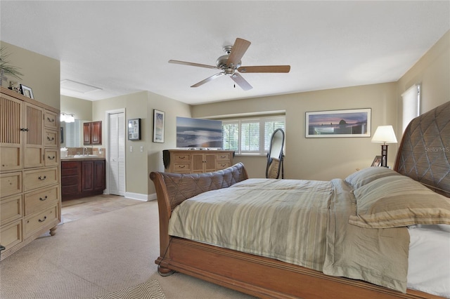 carpeted bedroom featuring ceiling fan, ensuite bathroom, and sink