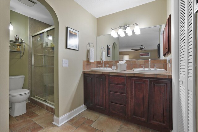 bathroom with walk in shower, toilet, ceiling fan, decorative backsplash, and vanity