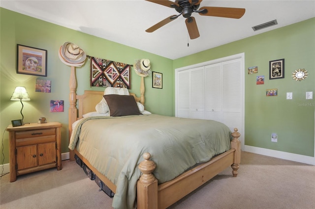 bedroom featuring a closet, visible vents, light carpet, ceiling fan, and baseboards