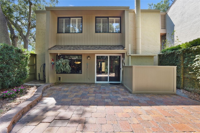 view of front of property with a patio area and a shingled roof