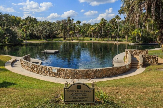 view of community featuring a lawn and a water view