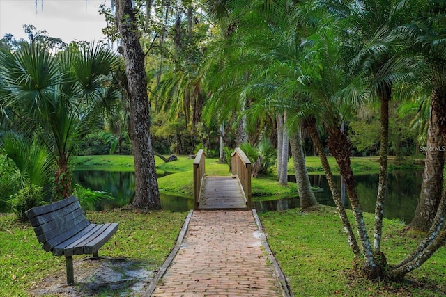 view of home's community with a lawn and a water view