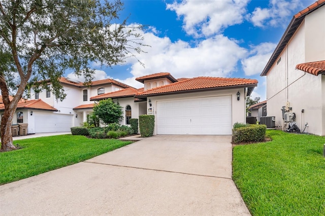 mediterranean / spanish home featuring a garage, central AC, and a front yard