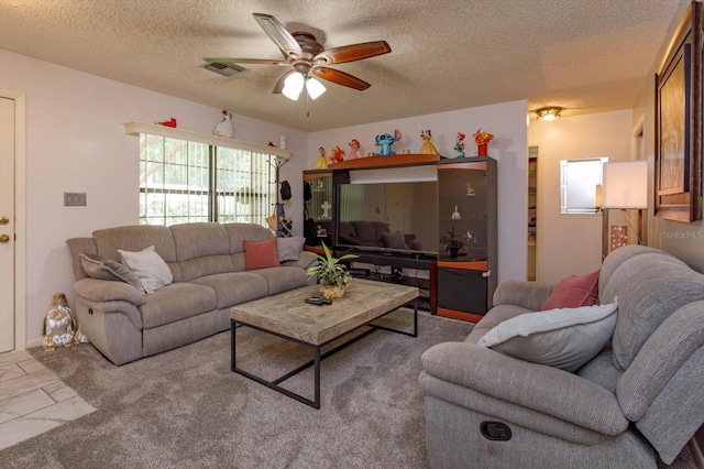 living room featuring ceiling fan, light colored carpet, and a textured ceiling