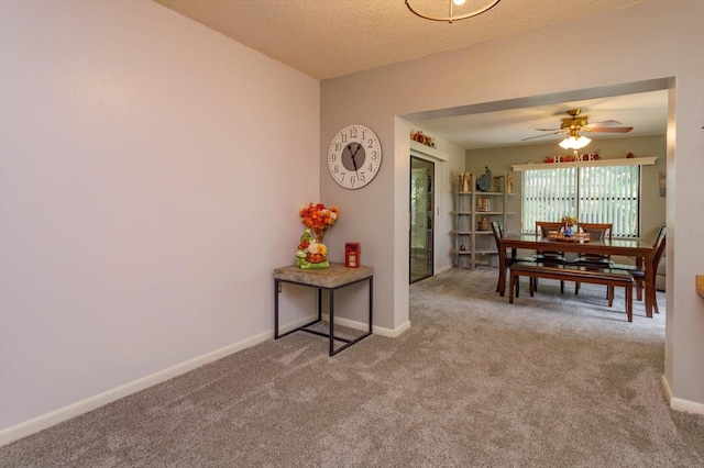 carpeted dining room featuring ceiling fan and a textured ceiling