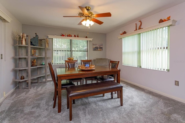 carpeted dining space with plenty of natural light and ceiling fan