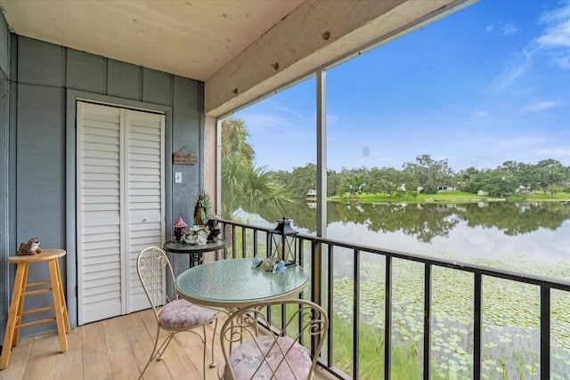 sunroom featuring a water view