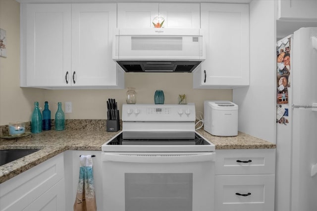 kitchen featuring light stone countertops, white appliances, and white cabinetry