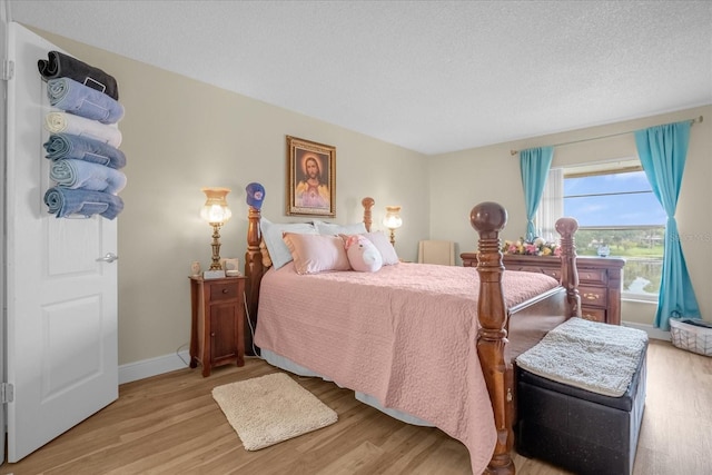 bedroom with a textured ceiling and light hardwood / wood-style flooring