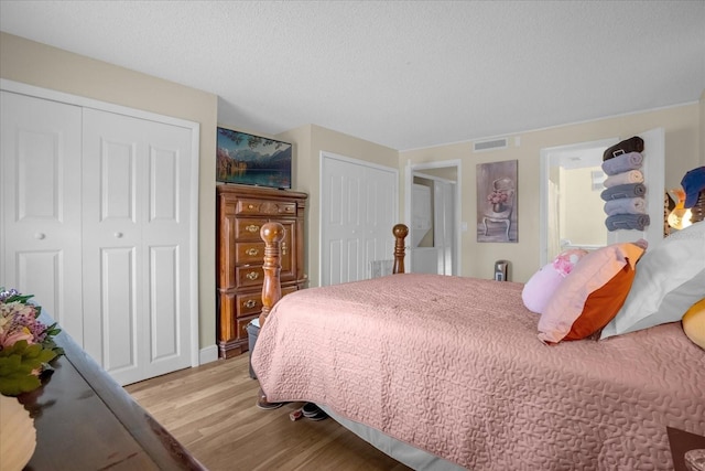 bedroom featuring two closets and light hardwood / wood-style flooring