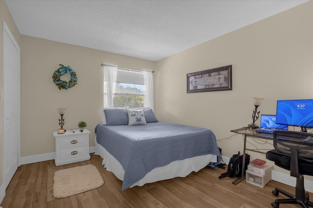 bedroom with a textured ceiling and hardwood / wood-style floors