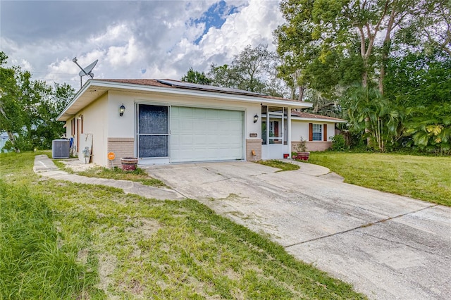 ranch-style home with a garage, a front lawn, and central AC