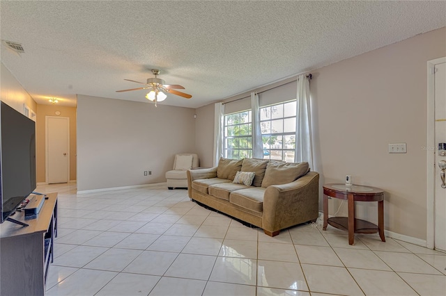 living room featuring a textured ceiling, light tile patterned flooring, and ceiling fan