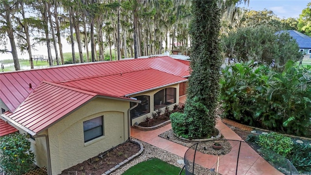 view of front of home with a standing seam roof, metal roof, and stucco siding