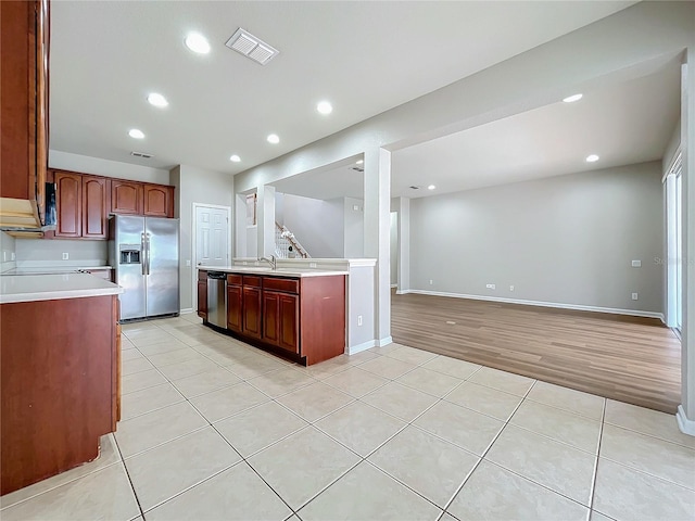 kitchen with stainless steel appliances, sink, and light hardwood / wood-style floors