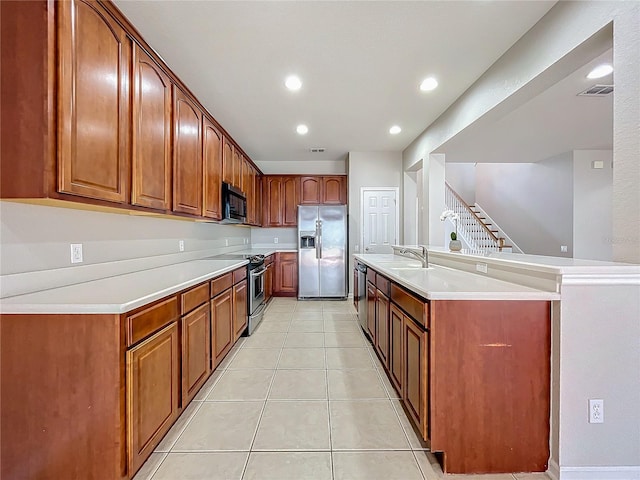 kitchen with light tile patterned floors, stainless steel appliances, and sink