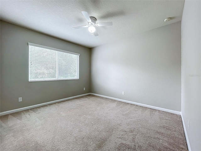 unfurnished room featuring a textured ceiling, light colored carpet, and ceiling fan