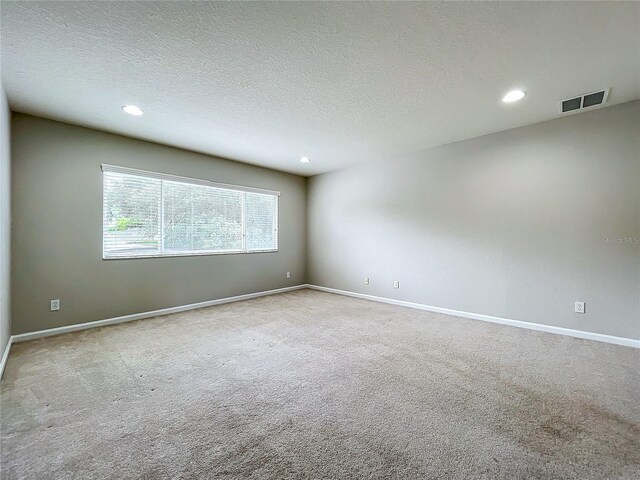 carpeted spare room featuring a textured ceiling