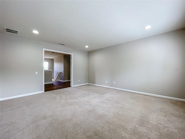 spare room with a textured ceiling and carpet flooring