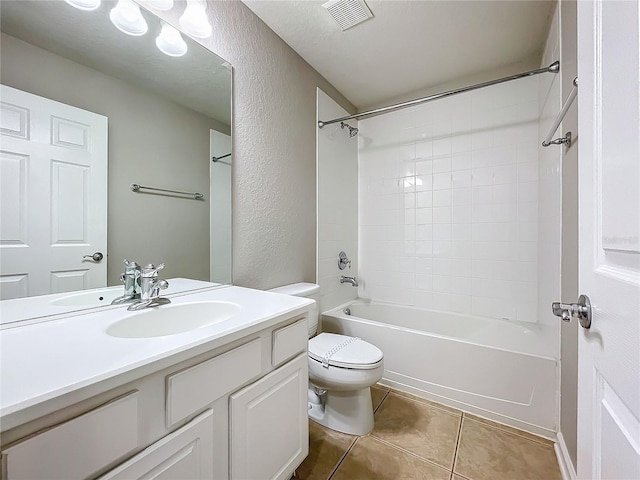 full bathroom featuring tiled shower / bath, tile patterned floors, toilet, vanity, and a textured ceiling