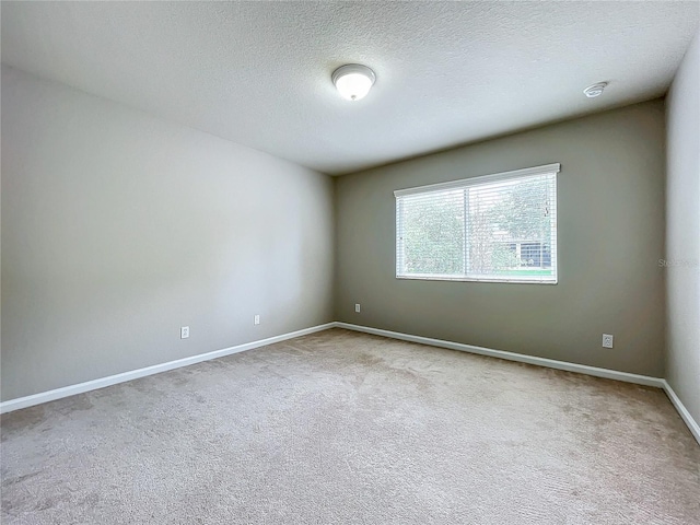 empty room featuring light carpet and a textured ceiling