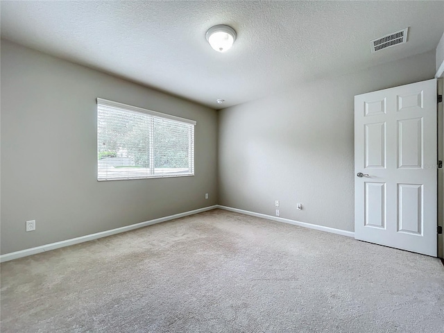 carpeted spare room featuring a textured ceiling