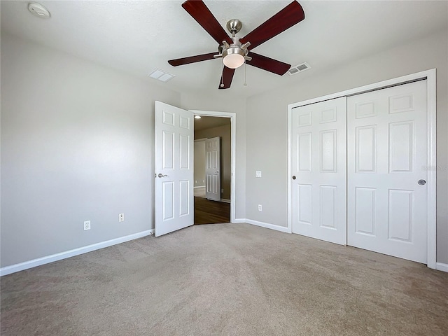 unfurnished bedroom featuring light colored carpet, ceiling fan, and a closet