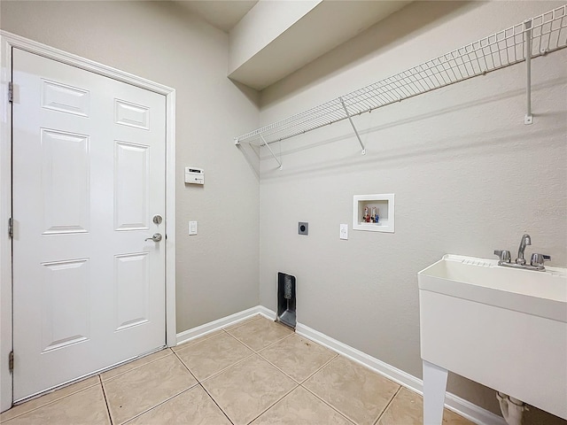 washroom featuring hookup for a washing machine, sink, light tile patterned floors, and electric dryer hookup