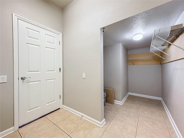 interior space with a textured ceiling and light tile patterned flooring