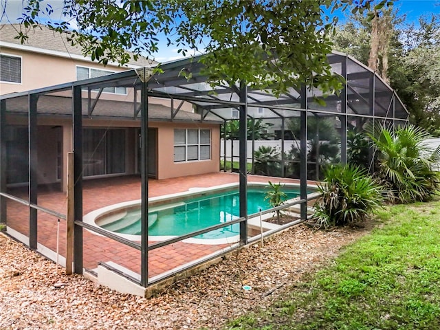 view of pool featuring a patio area and glass enclosure