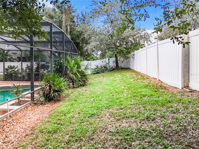 view of yard with a fenced in pool and a lanai