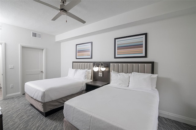 carpeted bedroom with a textured ceiling and ceiling fan