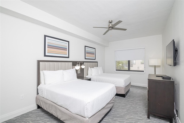 carpeted bedroom featuring a textured ceiling and ceiling fan