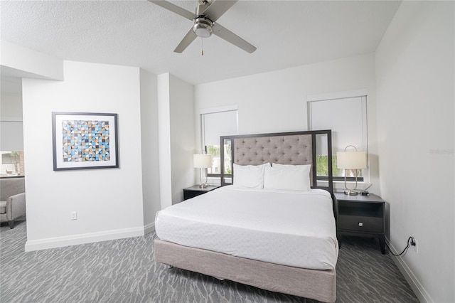 bedroom featuring carpet flooring, multiple windows, ceiling fan, and a textured ceiling