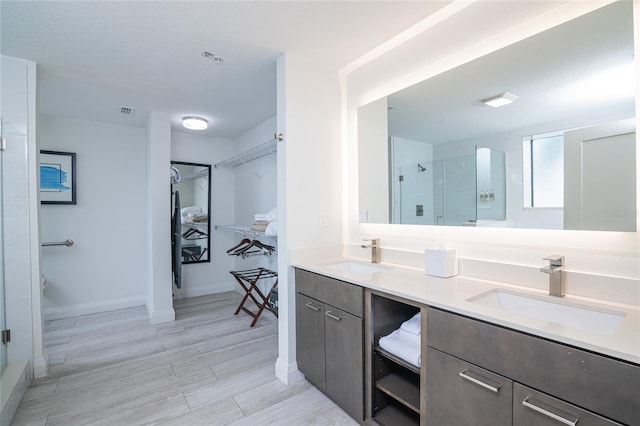 bathroom featuring vanity, a textured ceiling, wood-type flooring, and walk in shower