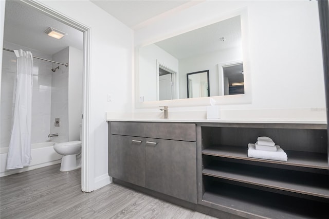 full bathroom featuring a textured ceiling, vanity, wood-type flooring, toilet, and shower / bath combo with shower curtain