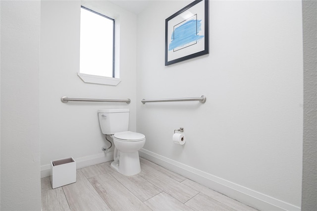 bathroom featuring wood-type flooring and toilet