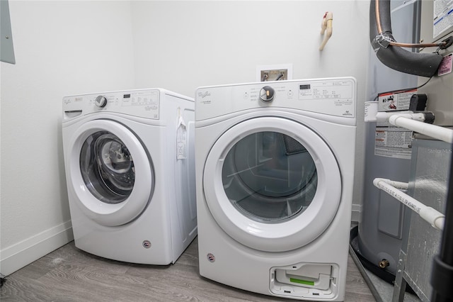 laundry area with independent washer and dryer, electric water heater, and hardwood / wood-style floors