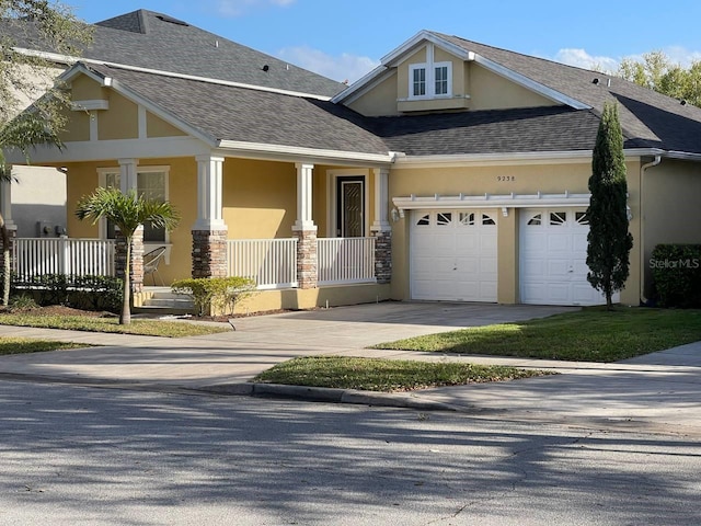 craftsman inspired home featuring stucco siding, covered porch, concrete driveway, a shingled roof, and a garage