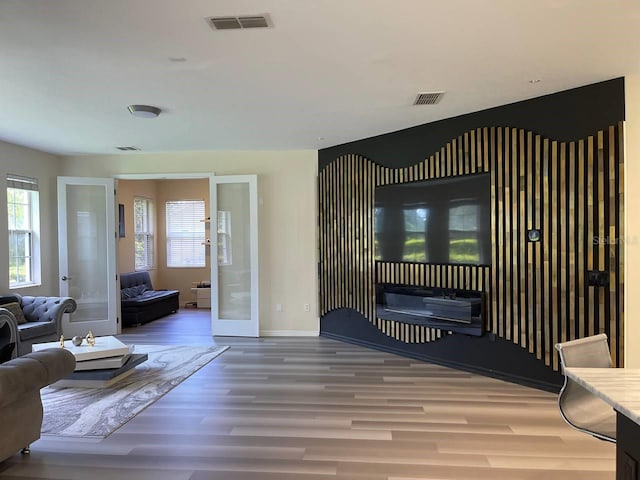 living room with visible vents, french doors, baseboards, and wood finished floors