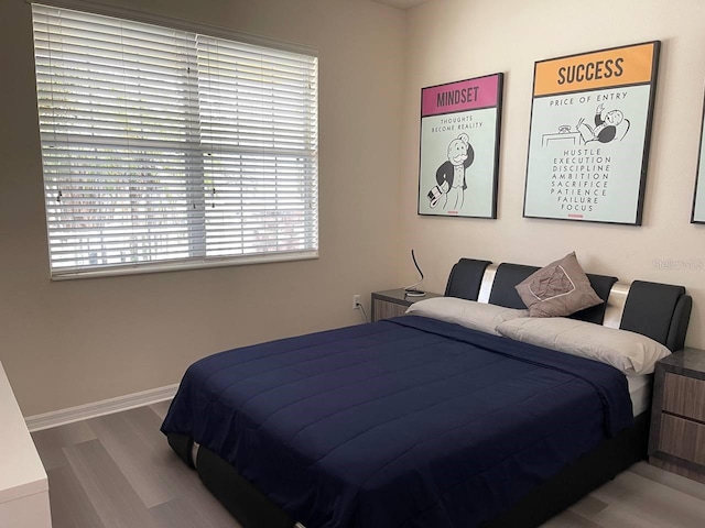 bedroom featuring wood finished floors and baseboards