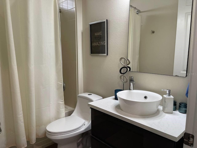 full bathroom with toilet, shower / bath combo, vanity, and a textured wall