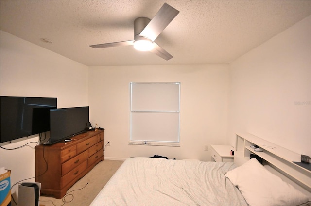 bedroom with light colored carpet, ceiling fan, and a textured ceiling