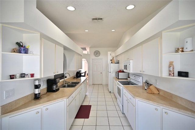 10255 Norwick St, Spring Hill, FL 34608 - kitchen featuring white appliances, light tile patterned floors, open shelves, a sink, and white cabinetry