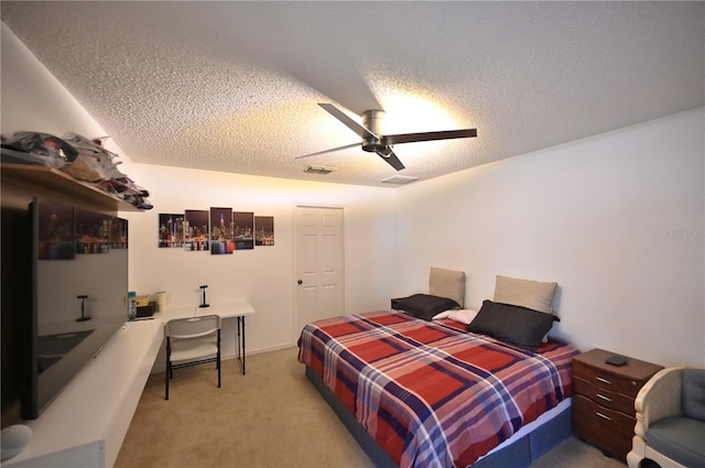 carpeted bedroom with a textured ceiling and ceiling fan