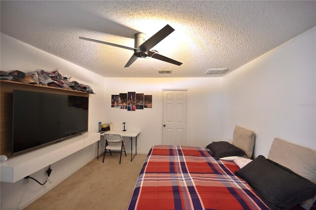 carpeted bedroom featuring a textured ceiling and ceiling fan