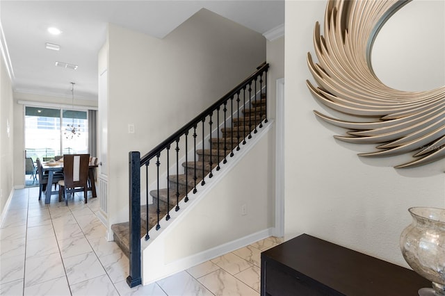 staircase featuring a chandelier and ornamental molding